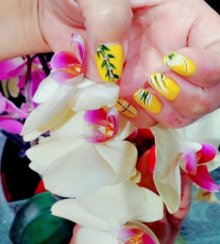 Nagelmodellage in Gelb mit weißer Orchidee