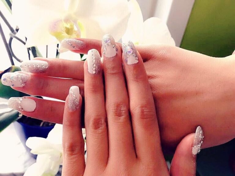 Nagelmodellage mit Glitzer und weißer Orchidee