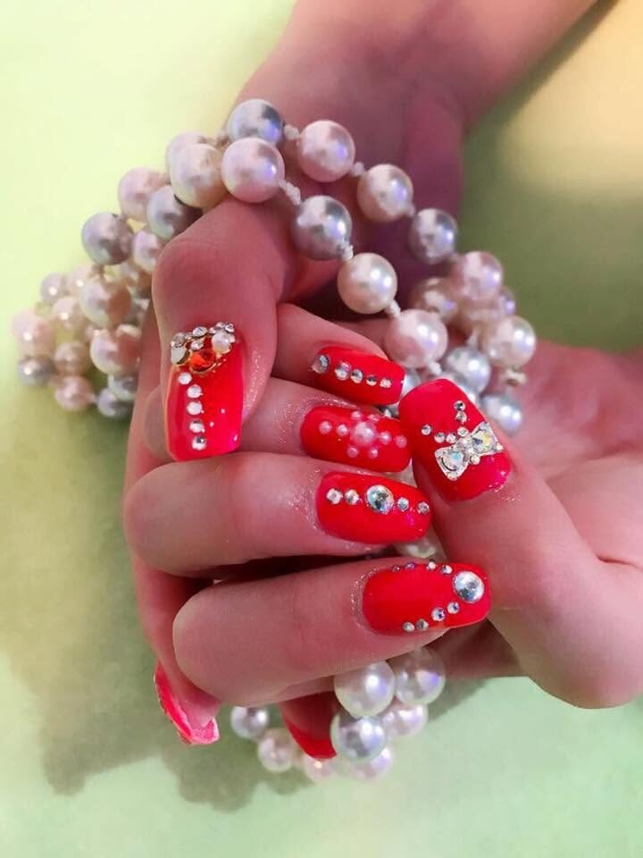 Rote Nagelmodellage mit Strass und Perlen